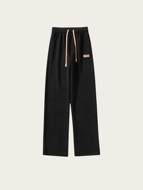 Black pants with a brand logo on a beige background