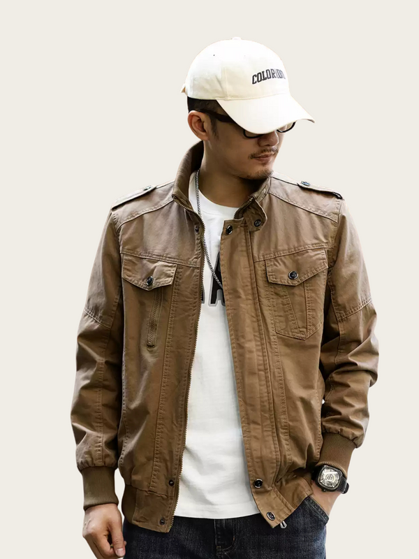 Man wearing a brown jacket, white shirt, and white cap on a plain background