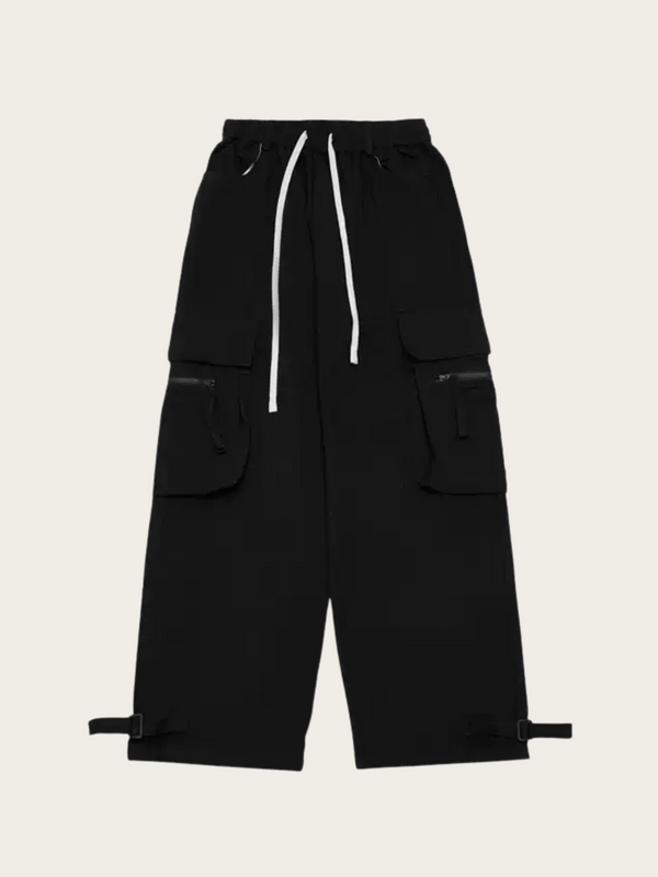 Black cargo pants with multiple pockets and drawstring on a beige background