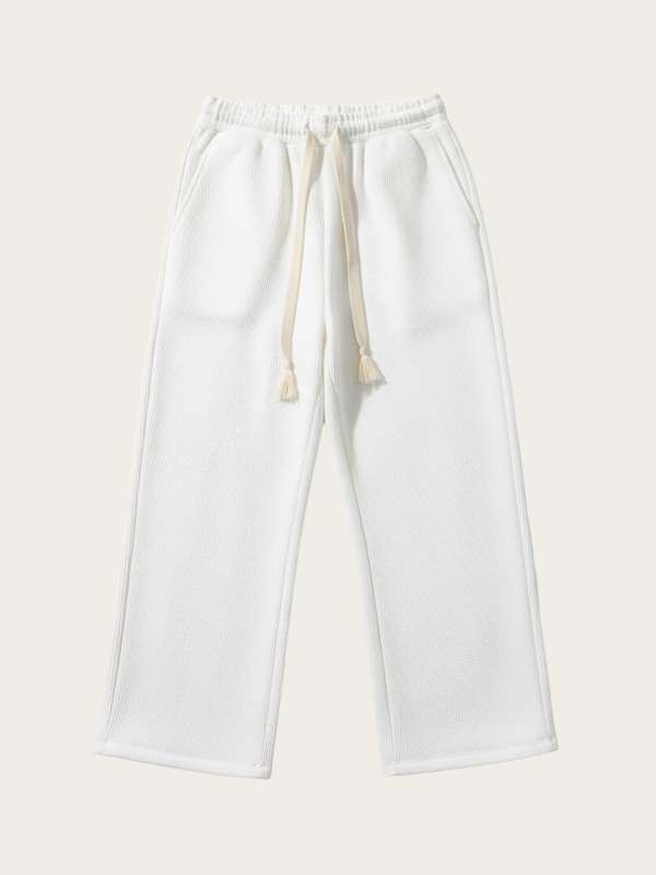 White sweatpants with drawstring on a light beige background
