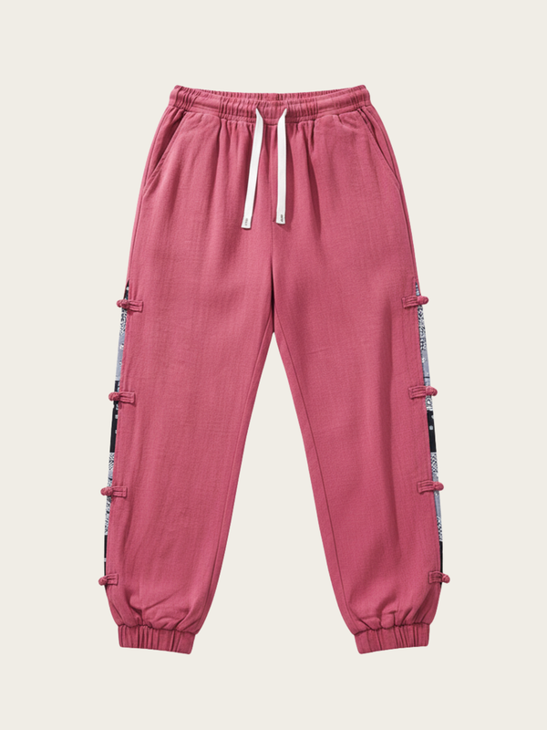 Pink jogger pants with side stripes on a beige background