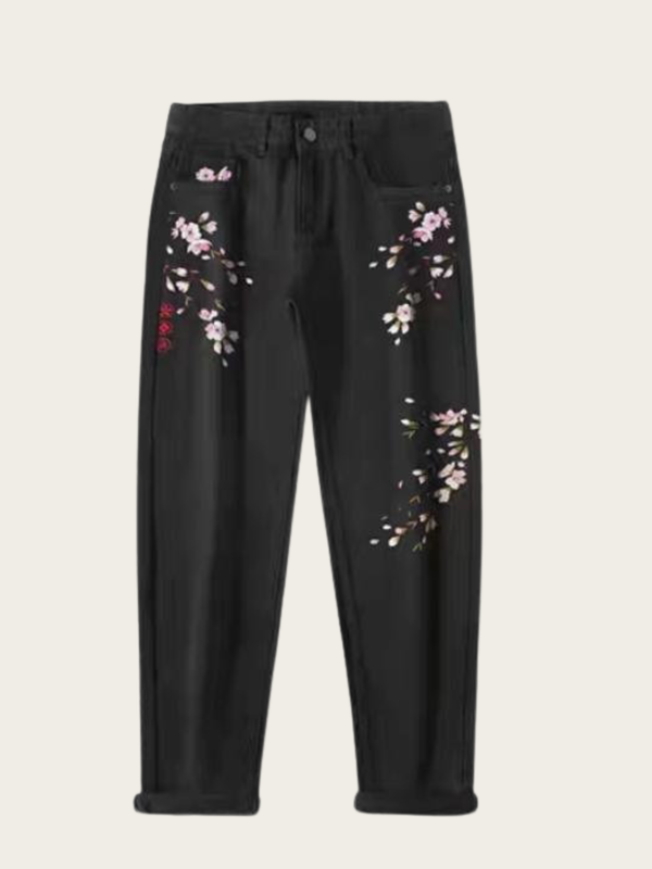 Black pants with floral embroidery on a light gray background