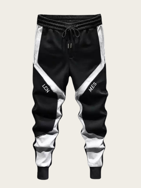 Black and white jogger pants with 'LCN' and 'MES' text on a light gray background