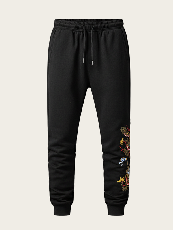Black jogger pants with a colorful dragon design on a beige background