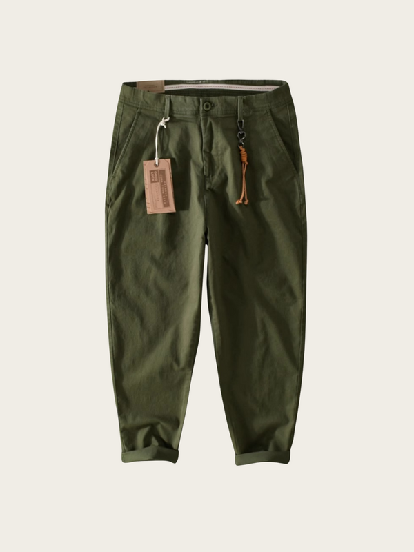 Green pants with a tag on a light beige background
