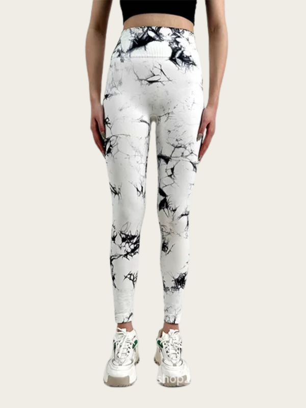 Person wearing white leggings with black abstract patterns on a white background