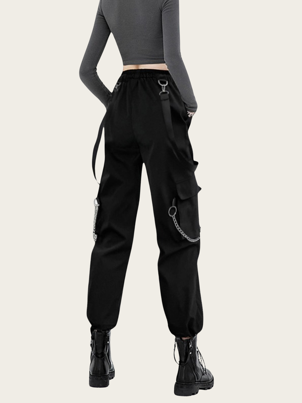 Person wearing black cargo pants with chain details on a white background