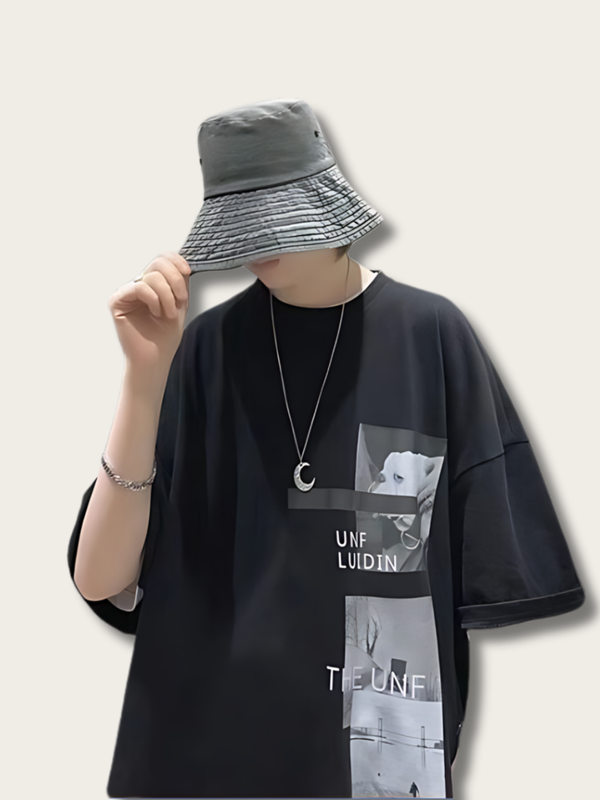 Person wearing a black t-shirt with graphic design and a gray bucket hat on a light background