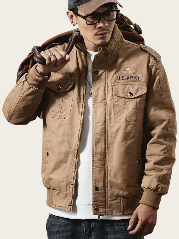 Man wearing a U.S. Army jacket on a plain background