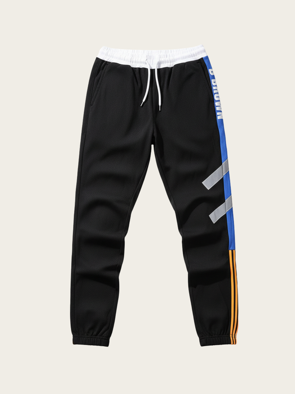 Black jogger pants with colorful side stripes on a beige background
