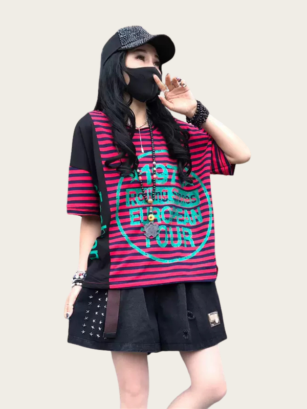 Person wearing a black and red striped shirt with text, black skirt, and cap on a plain background