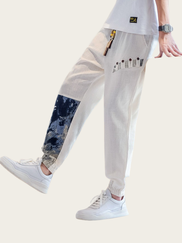 Person wearing a white outfit with a unique patterned patch on a light background