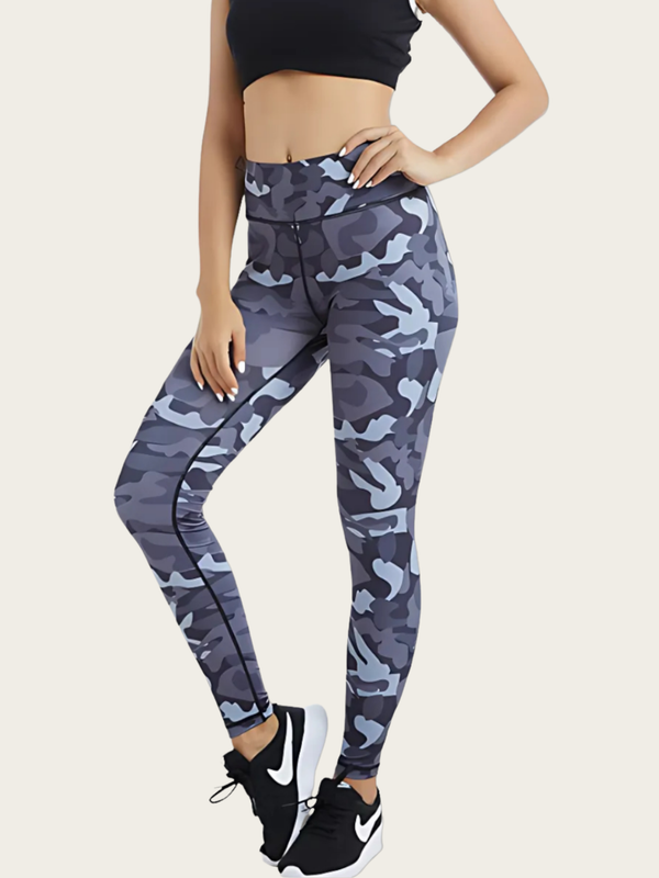 Person wearing camouflage leggings and black Nike sneakers on a light background