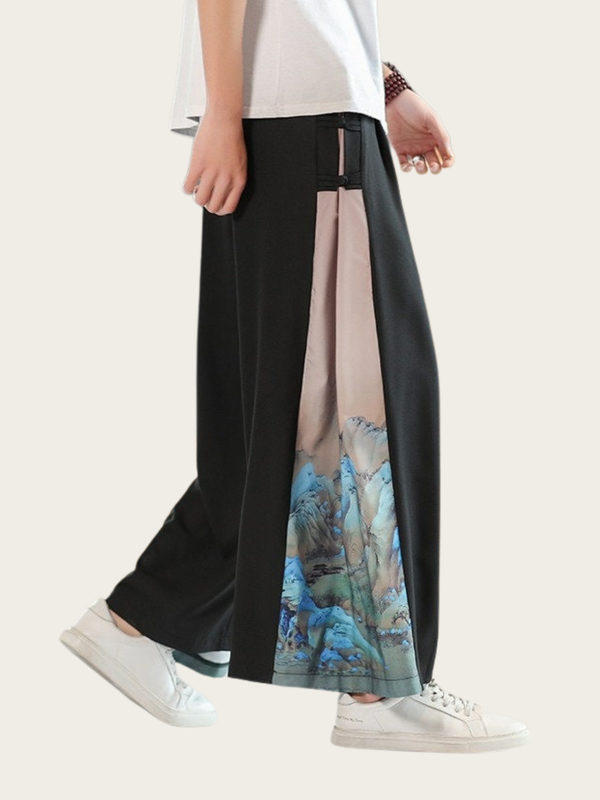 Person wearing a black skirt with a scenic print on a plain background