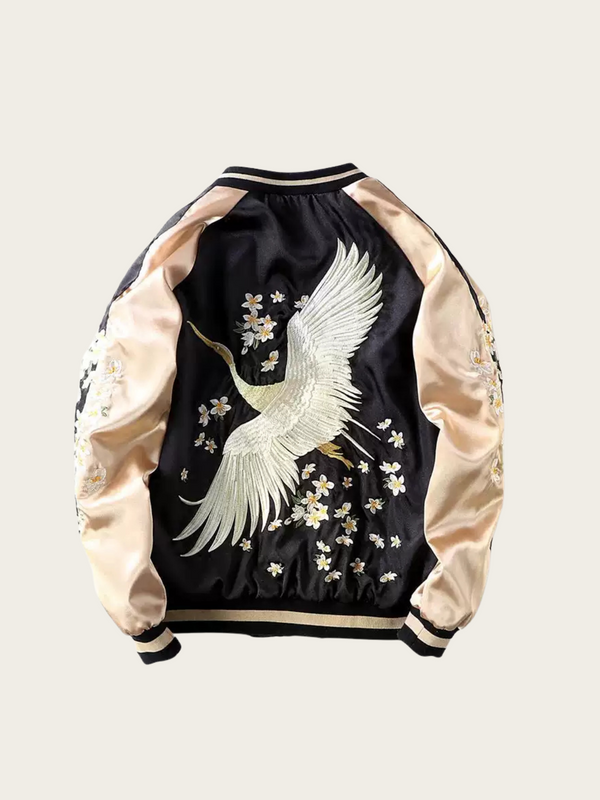 Black bomber jacket with white crane and floral embroidery on a light gray background