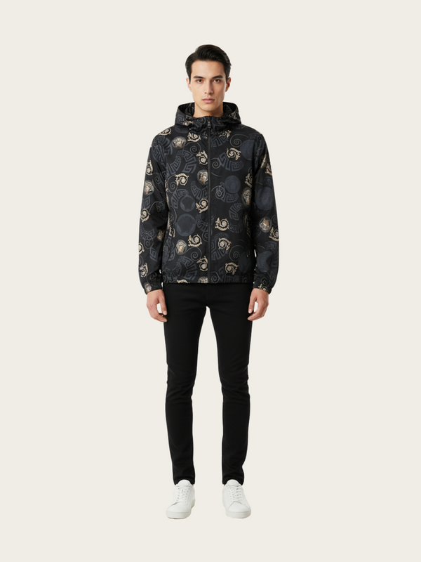 Man wearing a dark patterned jacket and black pants on a white background