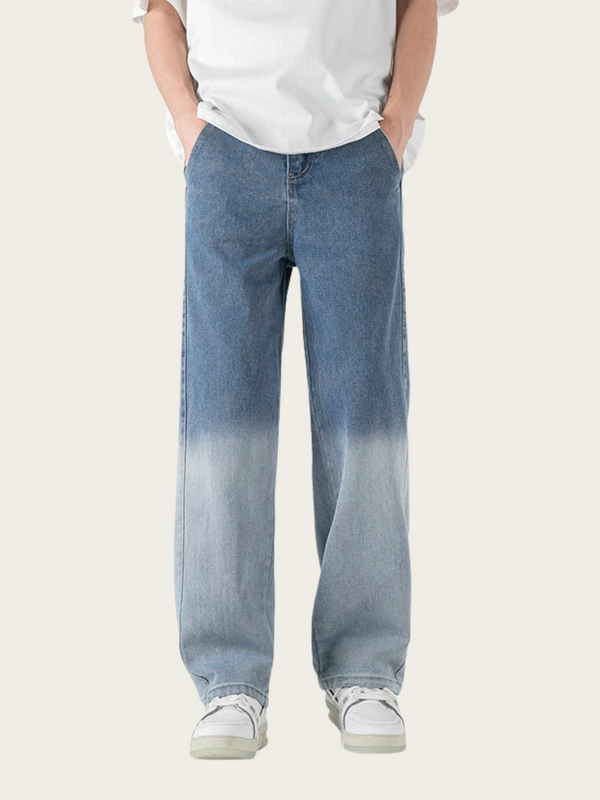 Person wearing blue gradient jeans and white sneakers on a white background