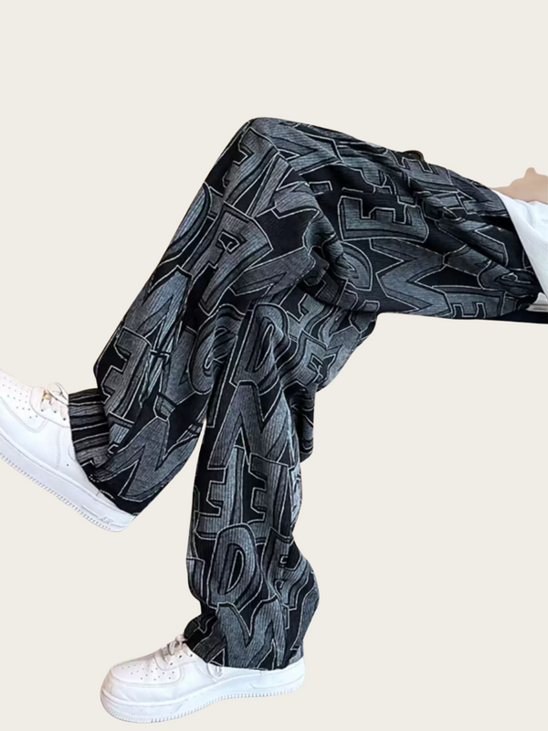 Person wearing dark gray pants with a geometric pattern on a beige background