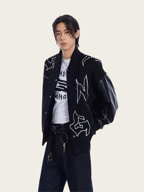 Person wearing a black jacket with white designs on a plain background