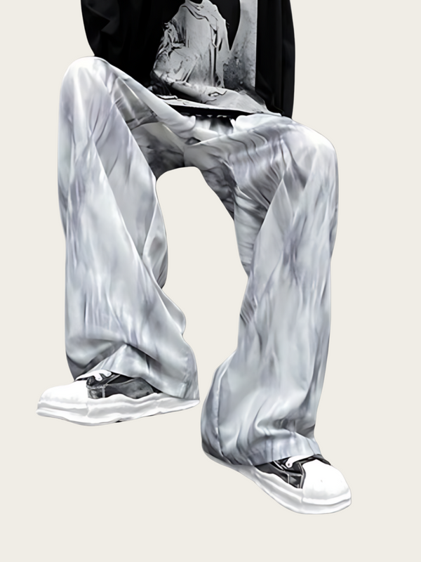 Person wearing gray marbled pants with white sneakers on a light background
