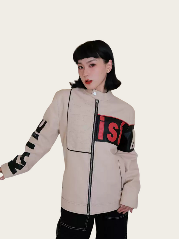 Person wearing a beige jacket with black and red accents on a plain background