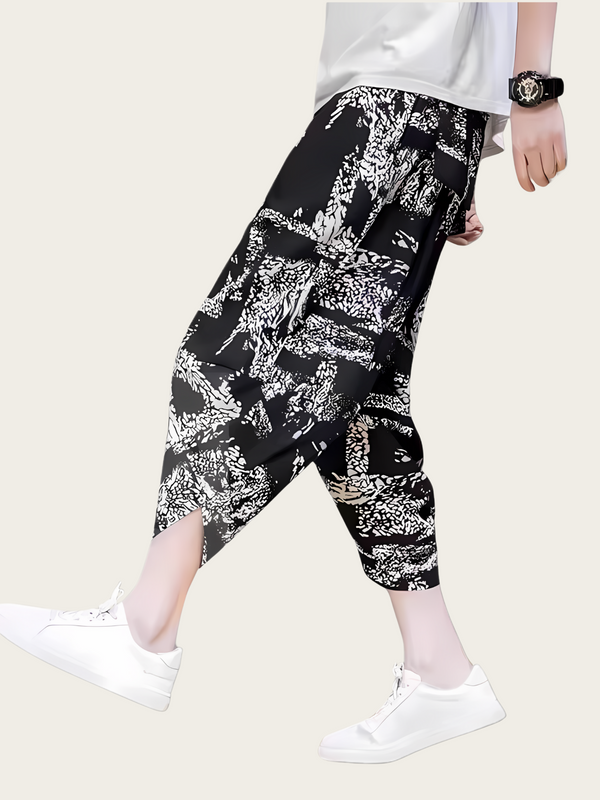 Person wearing black and white patterned pants on a white background
