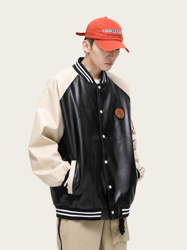 Person wearing a black and beige varsity jacket with a red cap on a white background