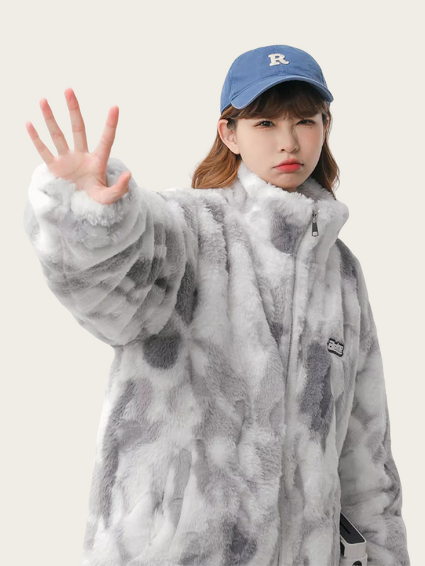 Person wearing a gray camouflage jacket and blue cap on a plain background