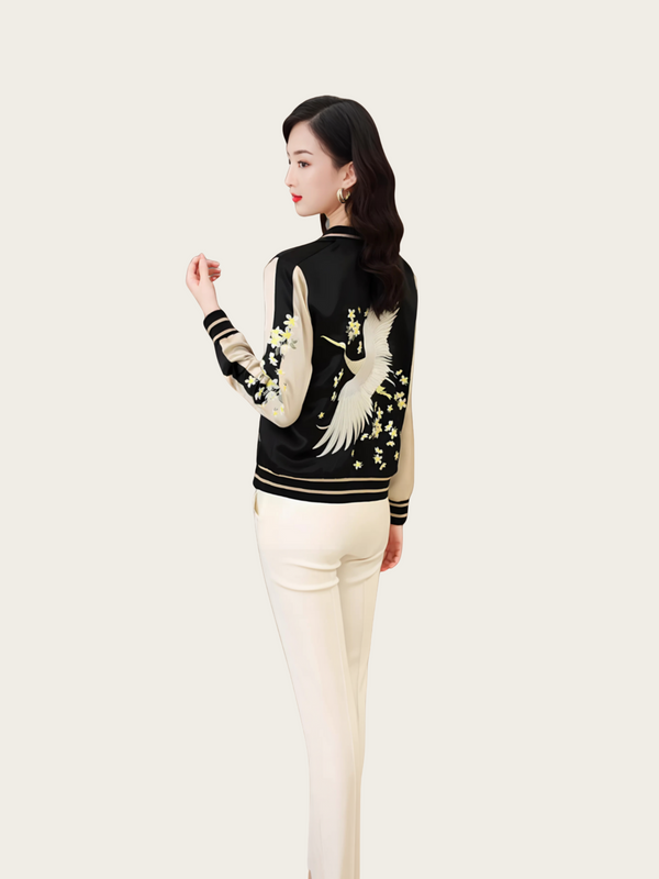 Woman wearing a black jacket with white crane designs on a white background