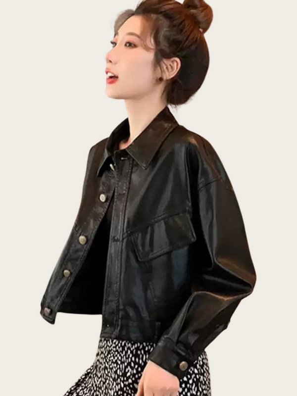 Woman wearing a black leather jacket on a plain background