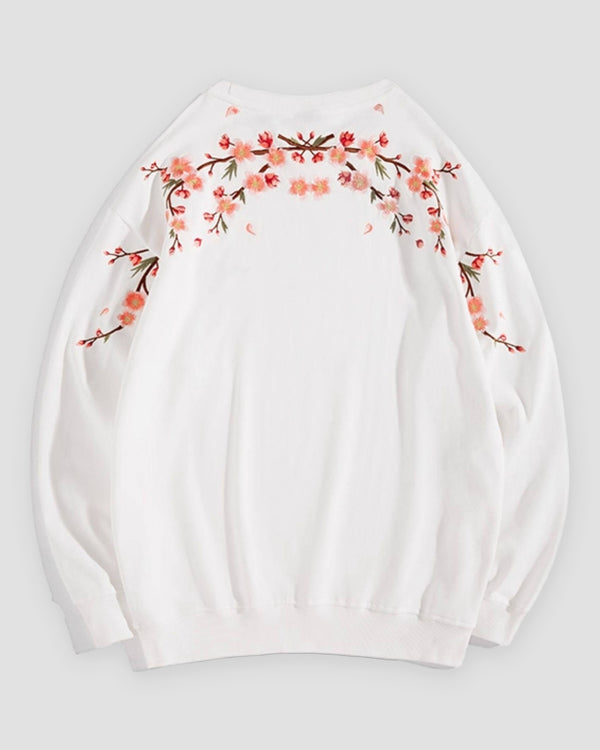 White crew-neck sweatshirt laid flat, back with blossom branches across the shoulders