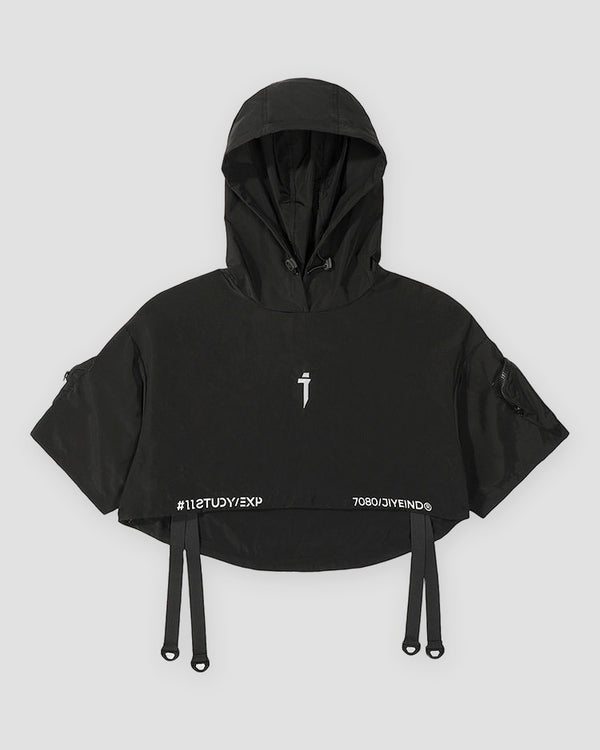 Black cropped hooded poncho top with ring straps at the hem, front view