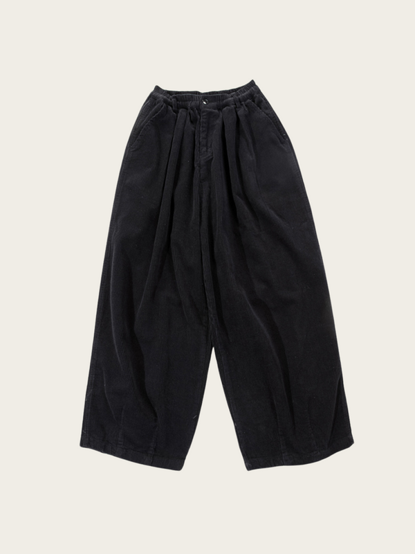 Black wide-leg pants on a light beige background