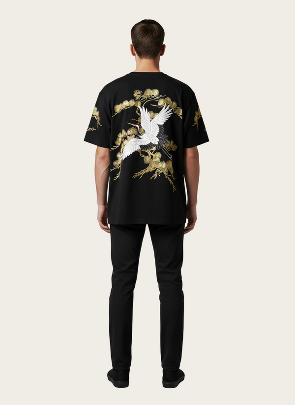 Person wearing a black t-shirt with a crane design on a gray background