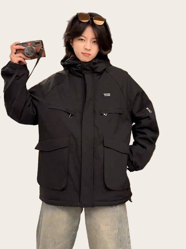 Person wearing a black jacket taking a mirror selfie indoors.