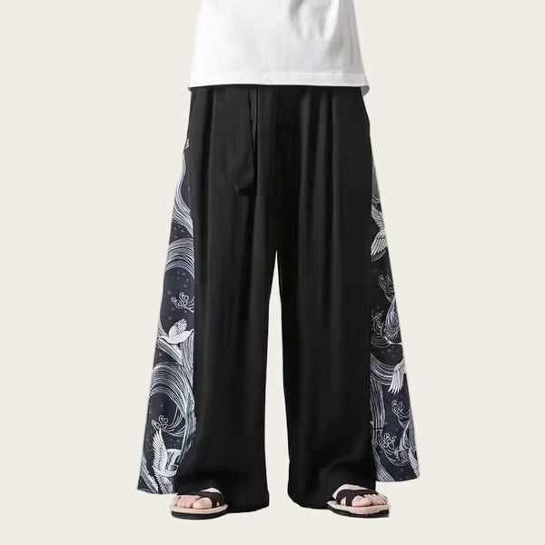 Person wearing black wide-leg pants with white patterns on a white background