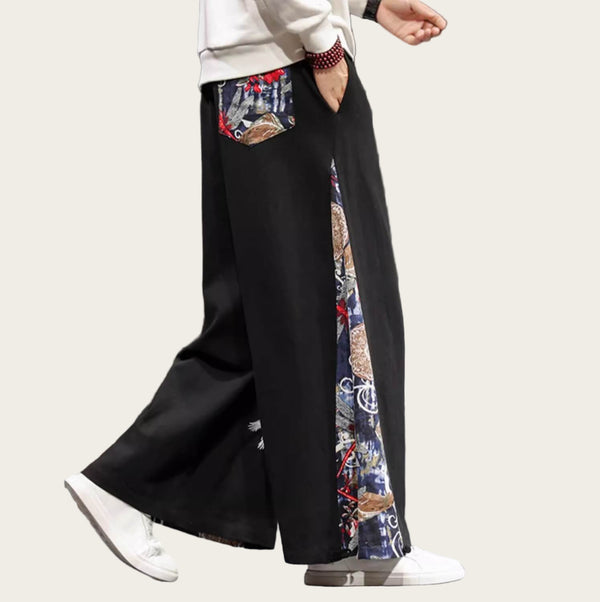 Person wearing black wide-leg pants with colorful side panels