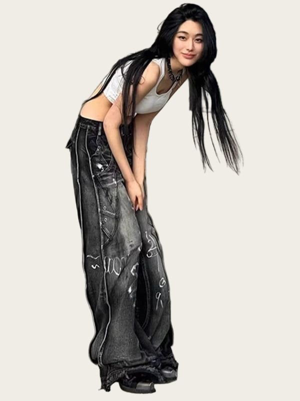 Woman in a white top and black distressed jeans standing.