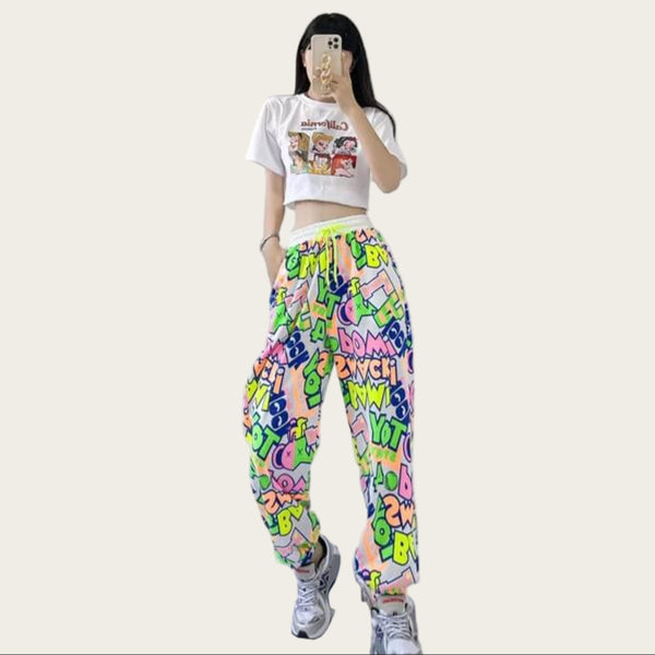 Person wearing a colorful graphic sweatshirt and pants standing