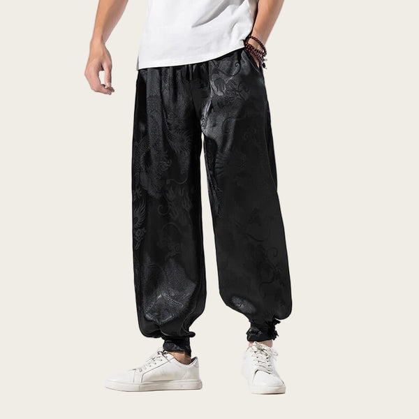 Person wearing black baggy pants and white sneakers on a yellow background