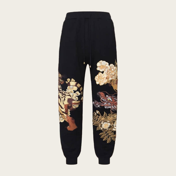 Black pants with floral embroidery on a yellow background