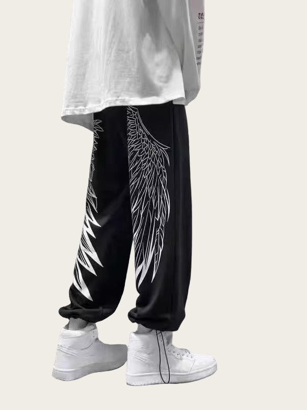 Person wearing black pants with white wing design and white sneakers