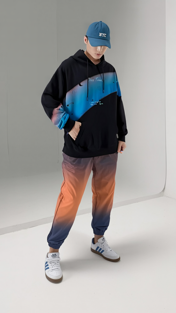 Person wearing a black and blue gradient hoodie with matching pants, standing against a plain background.