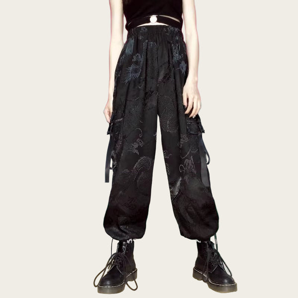 Person wearing black floral pants and black boots in a room with colorful walls.