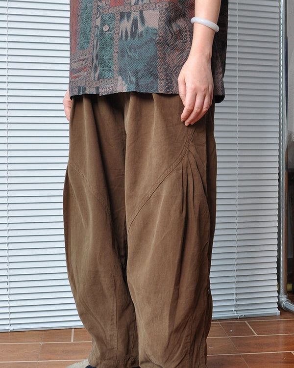 Deep brown barrel-leg canvas pants worn with a patterned shirt, front view