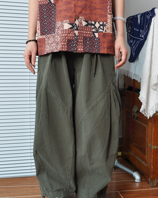 Olive barrel-leg canvas pants worn with a patterned shirt, front view