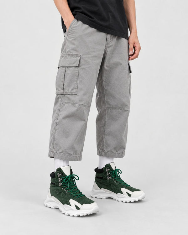 Model wearing the green high-top sneakers with light gray cargo trousers, front view