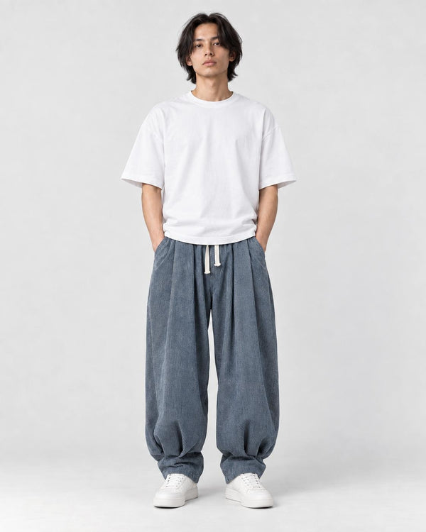 Model wearing the blue gray corduroy lantern pants with a white tee, front view