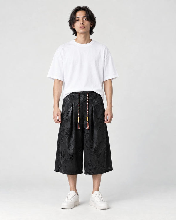 Model wearing the black dragon jacquard cropped wide-leg pants with a white tee and white sneakers, front view