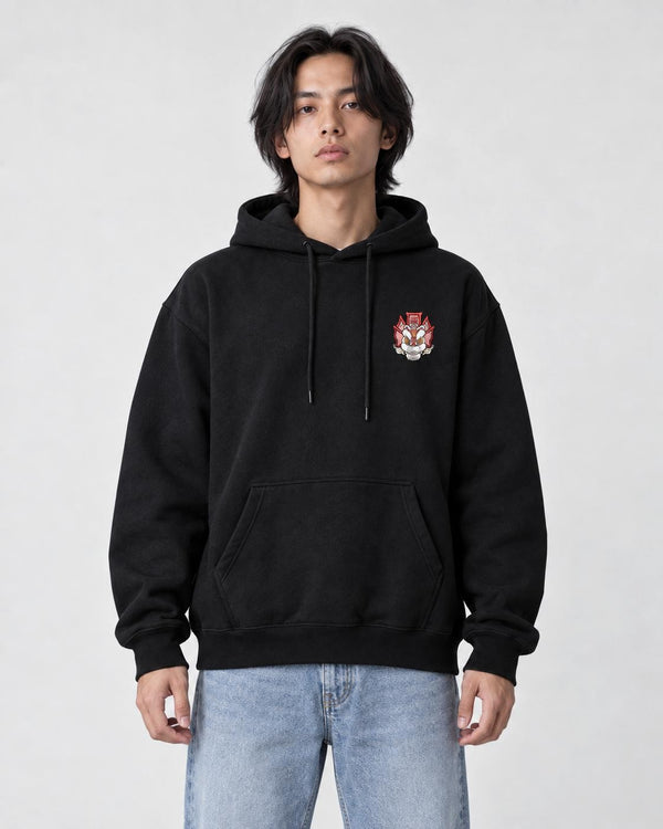 Model wearing the black hoodie with the small lion emblem on the chest, front view
